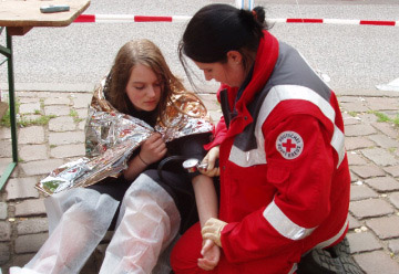 Retterin vom DRK misst Blutdruck an einer Verletzten