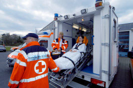Foto: Sanitäter bringen Patienten in den Krankenwagen