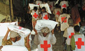 Freiwilligkeit: Rotkreuzhelfer tragen Hilfsgter